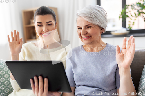 Image of daughter and mother having video call on tablet pc