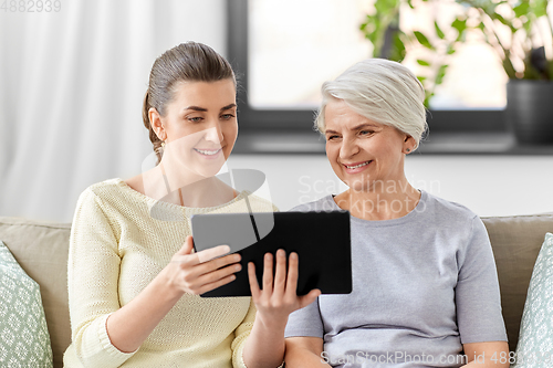 Image of daughter and senior mother with tablet pc at home