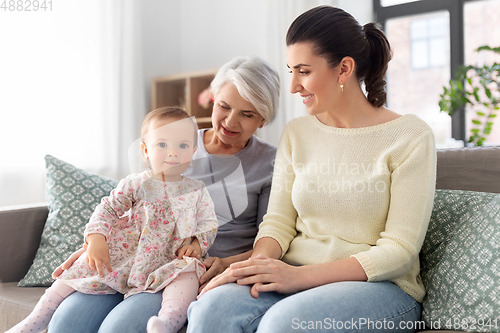 Image of mother, daughter and grandmother on sofa at home