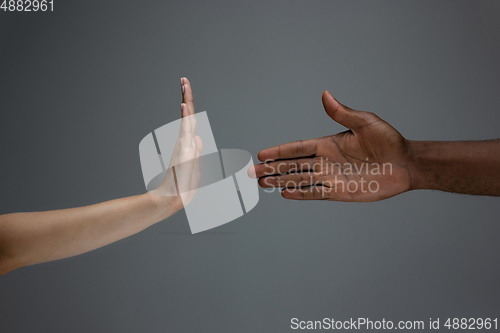 Image of Racial tolerance. Respect social unity. African and caucasian hands gesturing isolated on gray studio background