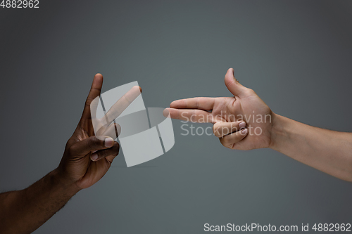 Image of Racial tolerance. Respect social unity. African and caucasian hands gesturing isolated on gray studio background