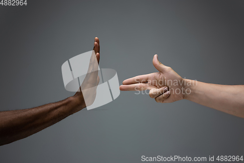 Image of Racial tolerance. Respect social unity. African and caucasian hands gesturing isolated on gray studio background