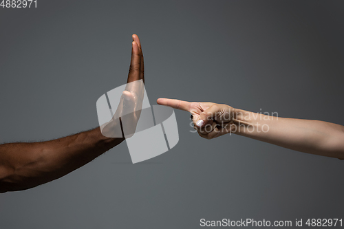 Image of Racial tolerance. Respect social unity. African and caucasian hands gesturing isolated on gray studio background