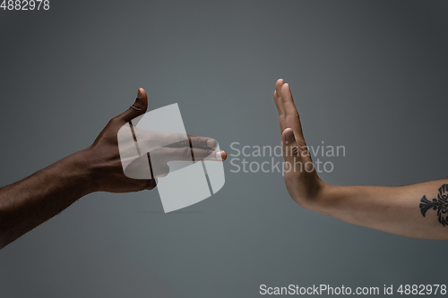 Image of Racial tolerance. Respect social unity. African and caucasian hands gesturing isolated on gray studio background