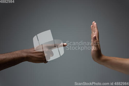 Image of Racial tolerance. Respect social unity. African and caucasian hands gesturing isolated on gray studio background