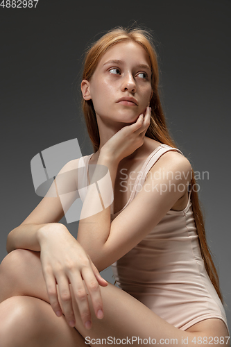 Image of Portrait of beautiful redhead woman isolated on grey studio background. Concept of beauty, skin care, fashion and style