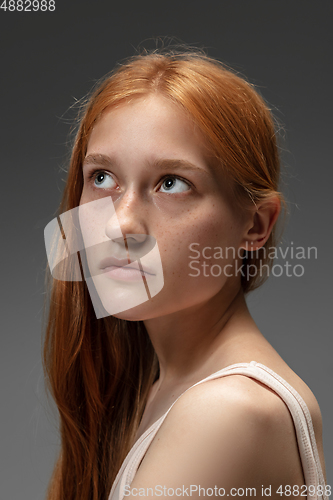 Image of Portrait of beautiful redhead woman isolated on grey studio background. Concept of beauty, skin care, fashion and style