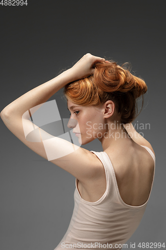 Image of Portrait of beautiful redhead woman isolated on grey studio background. Concept of beauty, skin care, fashion and style