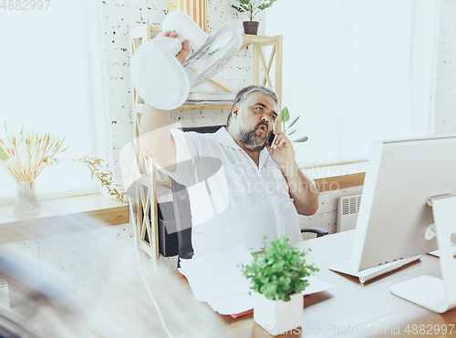 Image of Businessman, manager in office with computer and fan cooling off, feeling hot, flushed