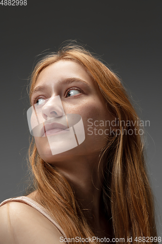 Image of Portrait of beautiful redhead woman isolated on grey studio background. Concept of beauty, skin care, fashion and style