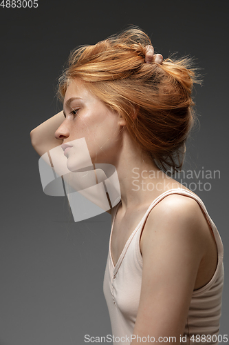 Image of Portrait of beautiful redhead woman isolated on grey studio background. Concept of beauty, skin care, fashion and style