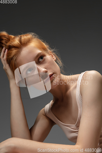 Image of Portrait of beautiful redhead woman isolated on grey studio background. Concept of beauty, skin care, fashion and style