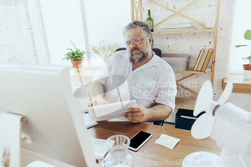 Image of Businessman, manager in office with computer and fan cooling off, feeling hot, flushed