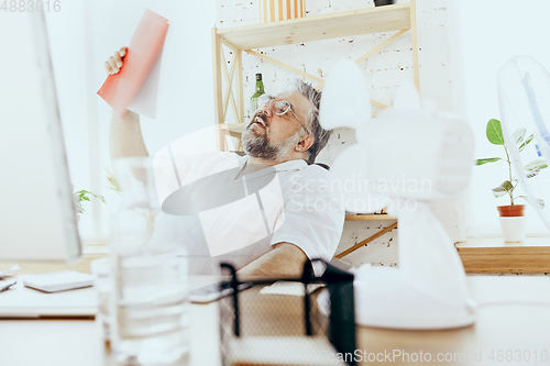 Image of Businessman, manager in office with computer and fan cooling off, feeling hot, flushed