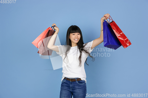 Image of Portrait of young asian woman isolated on blue studio background