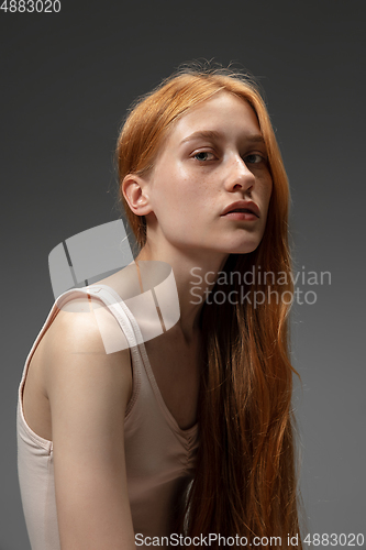 Image of Portrait of beautiful redhead woman isolated on grey studio background. Concept of beauty, skin care, fashion and style