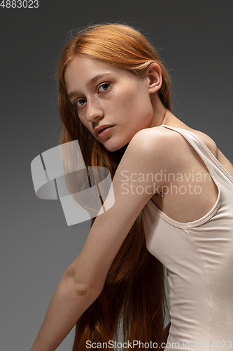 Image of Portrait of beautiful redhead woman isolated on grey studio background. Concept of beauty, skin care, fashion and style