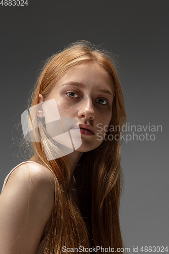 Image of Portrait of beautiful redhead woman isolated on grey studio background. Concept of beauty, skin care, fashion and style