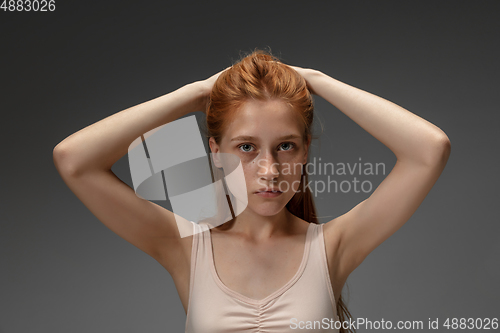 Image of Portrait of beautiful redhead woman isolated on grey studio background. Concept of beauty, skin care, fashion and style