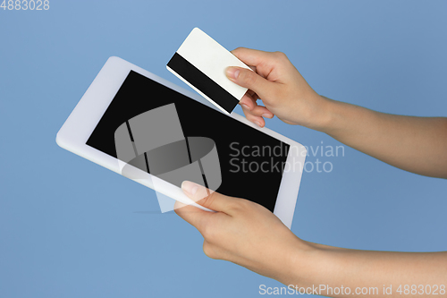 Image of Female hands with debit, credit card and tablet with copyspace on blank screen