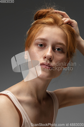 Image of Portrait of beautiful redhead woman isolated on grey studio background. Concept of beauty, skin care, fashion and style