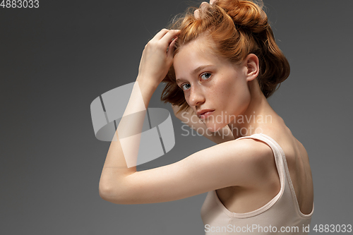 Image of Portrait of beautiful redhead woman isolated on grey studio background. Concept of beauty, skin care, fashion and style