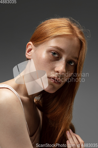 Image of Portrait of beautiful redhead woman isolated on grey studio background. Concept of beauty, skin care, fashion and style