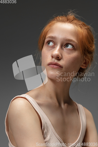 Image of Portrait of beautiful redhead woman isolated on grey studio background. Concept of beauty, skin care, fashion and style