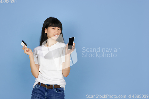 Image of Portrait of young asian woman isolated on blue studio background