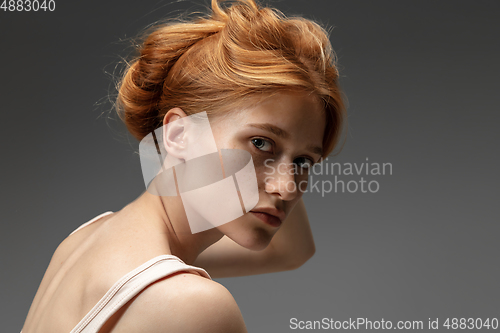 Image of Portrait of beautiful redhead woman isolated on grey studio background. Concept of beauty, skin care, fashion and style