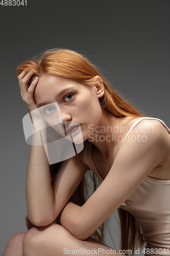 Image of Portrait of beautiful redhead woman isolated on grey studio background. Concept of beauty, skin care, fashion and style