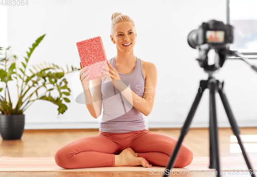 Image of woman with camera streaming for yoga blog at home