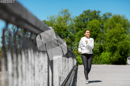 Image of african american woman running outdoors