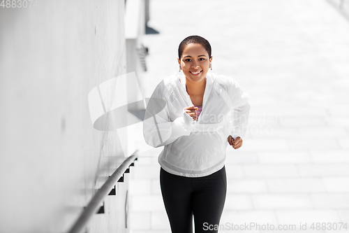 Image of african american woman running upstairs outdoors