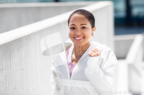 Image of african american woman running upstairs outdoors