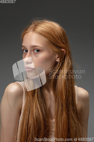 Image of Portrait of beautiful redhead woman isolated on grey studio background. Concept of beauty, skin care, fashion and style