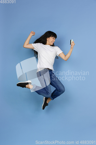 Image of Portrait of young asian woman isolated on blue studio background