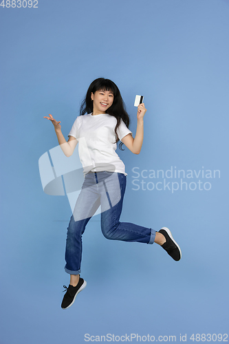 Image of Portrait of young asian woman isolated on blue studio background