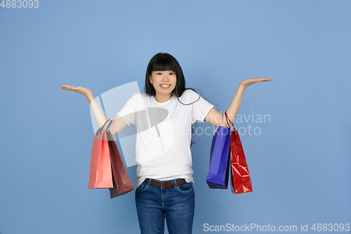 Image of Portrait of young asian woman isolated on blue studio background