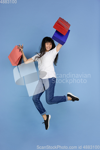 Image of Portrait of young asian woman isolated on blue studio background