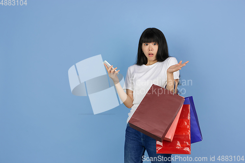 Image of Portrait of young asian woman isolated on blue studio background