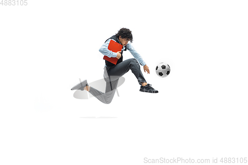 Image of Man in office clothes playing football or soccer with ball on white background. Unusual look for businessman in motion, action. Sport, healthy lifestyle.