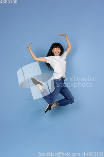 Image of Portrait of young asian woman isolated on blue studio background