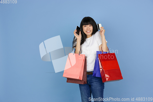 Image of Portrait of young asian woman isolated on blue studio background