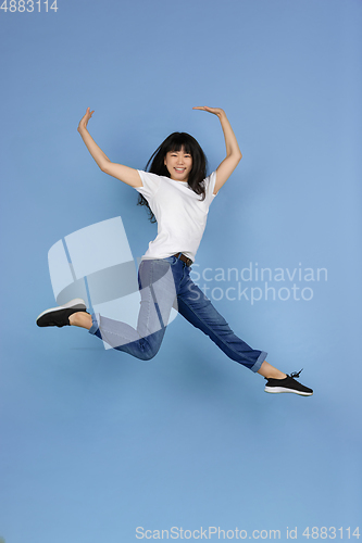 Image of Portrait of young asian woman isolated on blue studio background