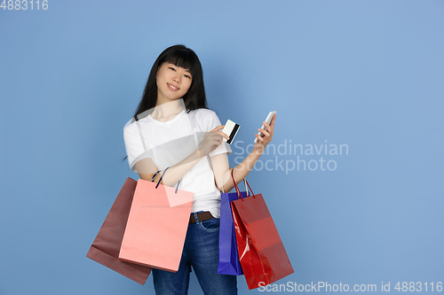 Image of Portrait of young asian woman isolated on blue studio background