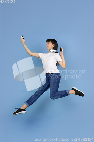 Image of Portrait of young asian woman isolated on blue studio background