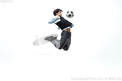 Image of Man in office clothes playing football or soccer with ball on white background. Unusual look for businessman in motion, action. Sport, healthy lifestyle.