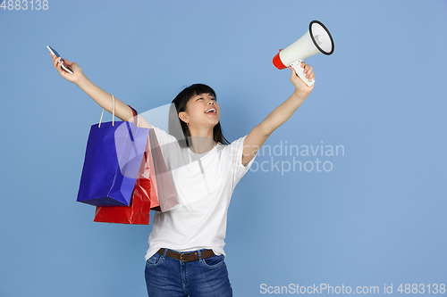 Image of Portrait of young asian woman isolated on blue studio background