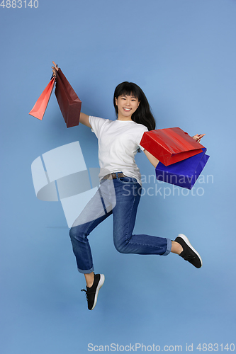 Image of Portrait of young asian woman isolated on blue studio background